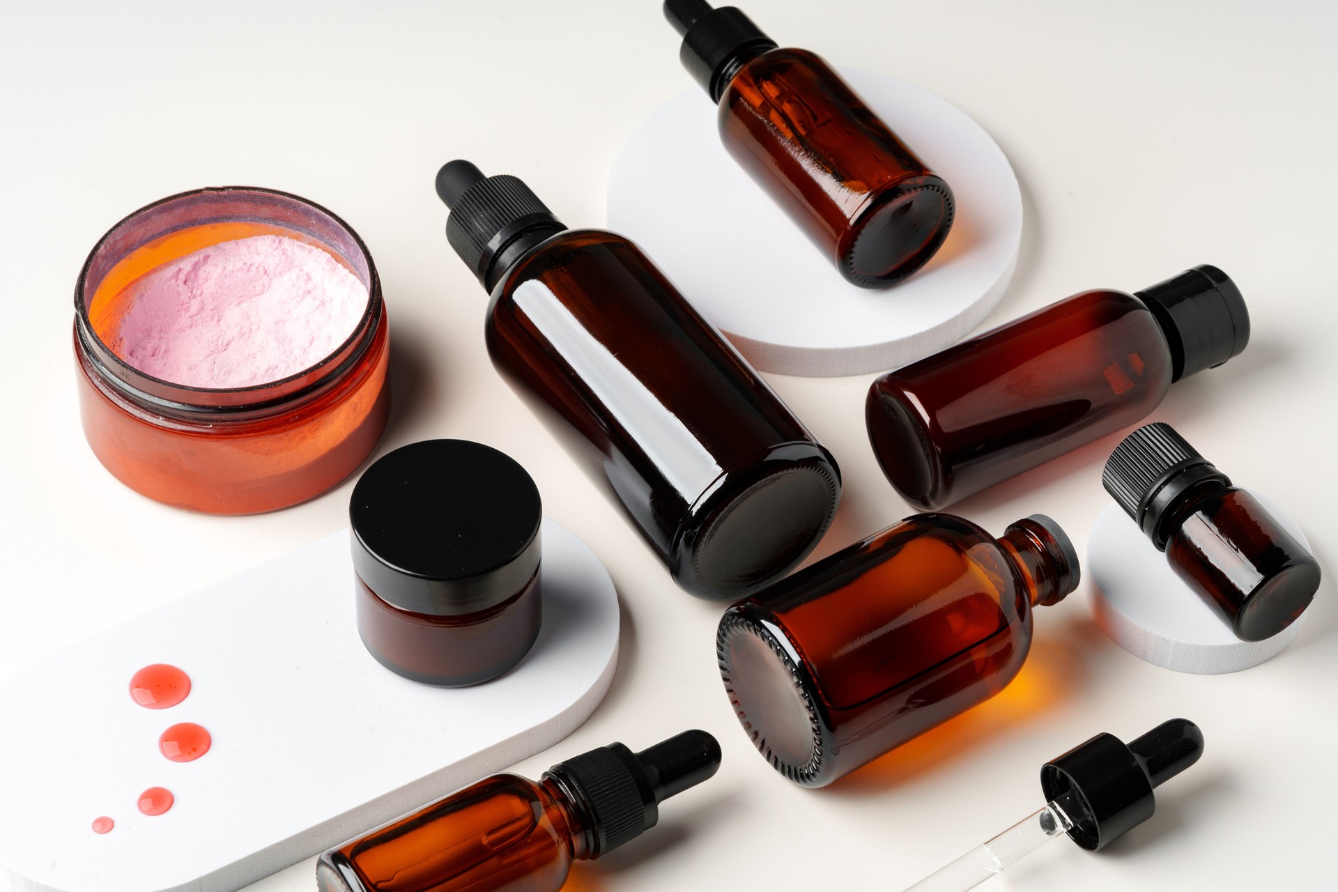 Amber Glass Bottles and Jars of Skincare Products on White Background