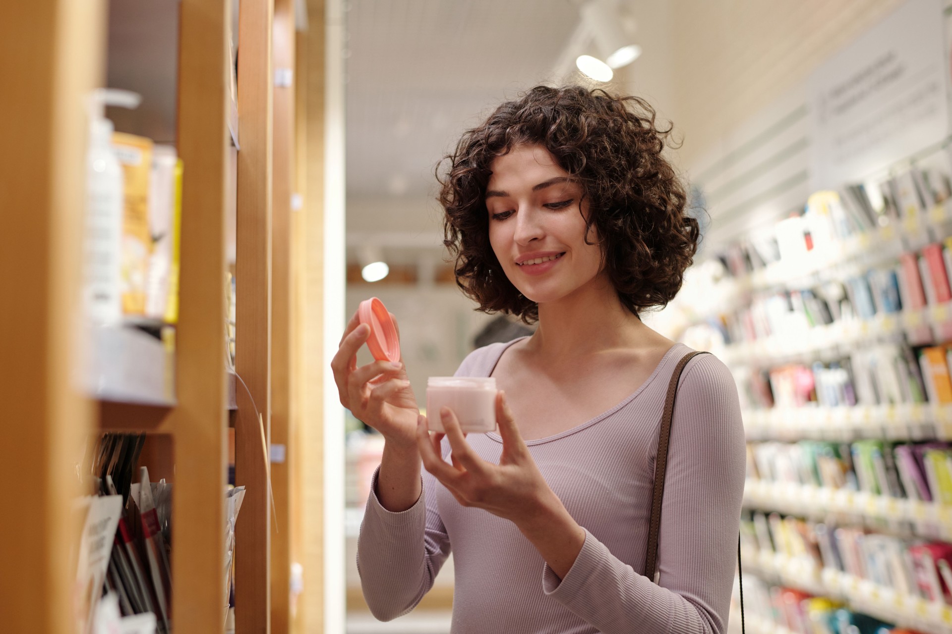 Woman opening jar of new facial cream